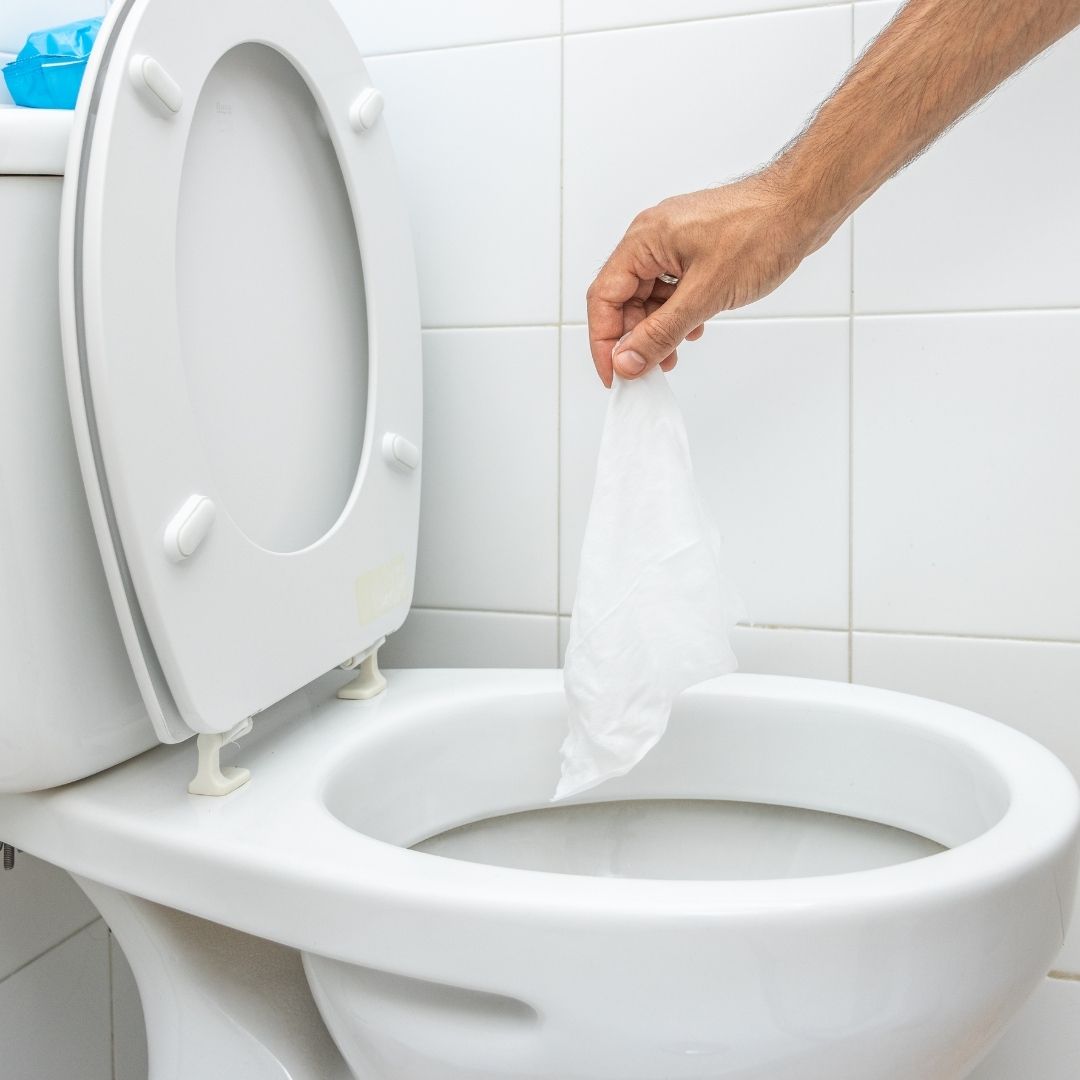 photo of someone throwing a wipe in the toilet